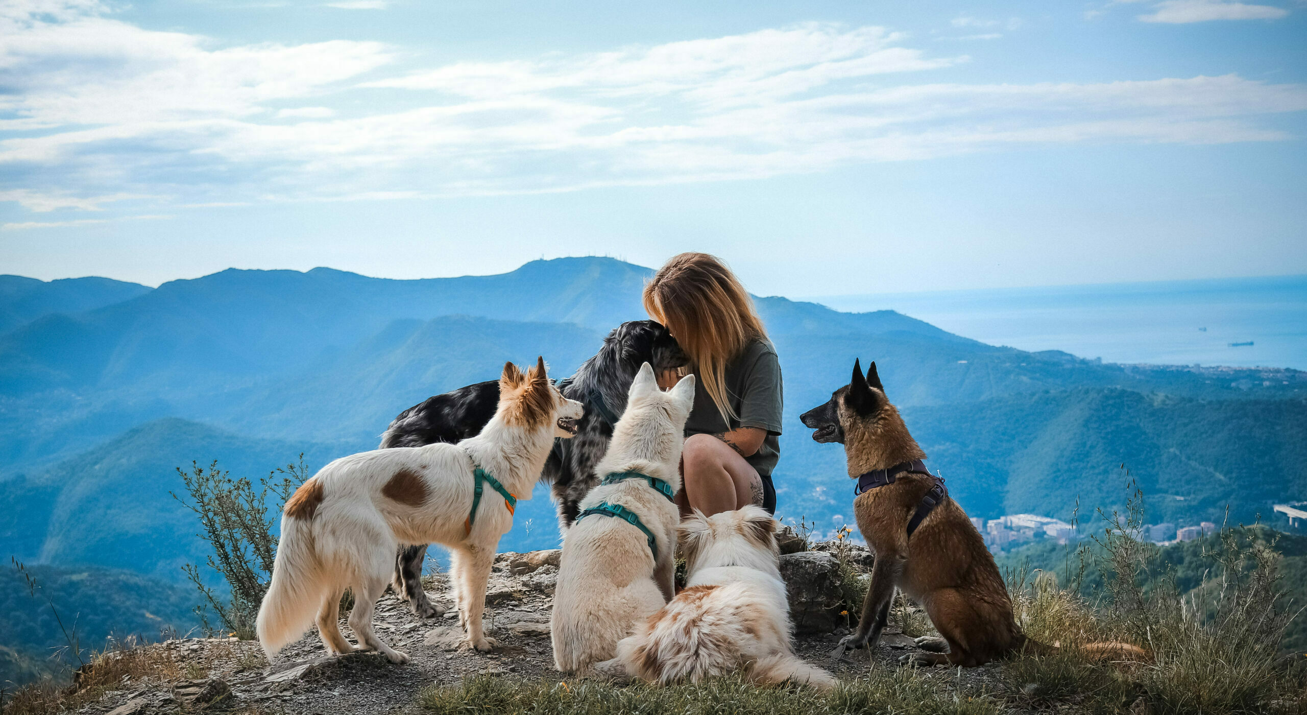 Emeline et son chien devant un lac turquoise entouré de sapins et de montagnes